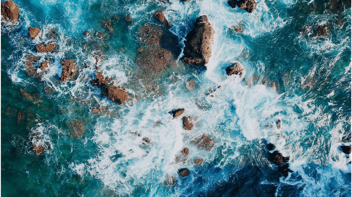Aerial view of a rough ocean and rocks