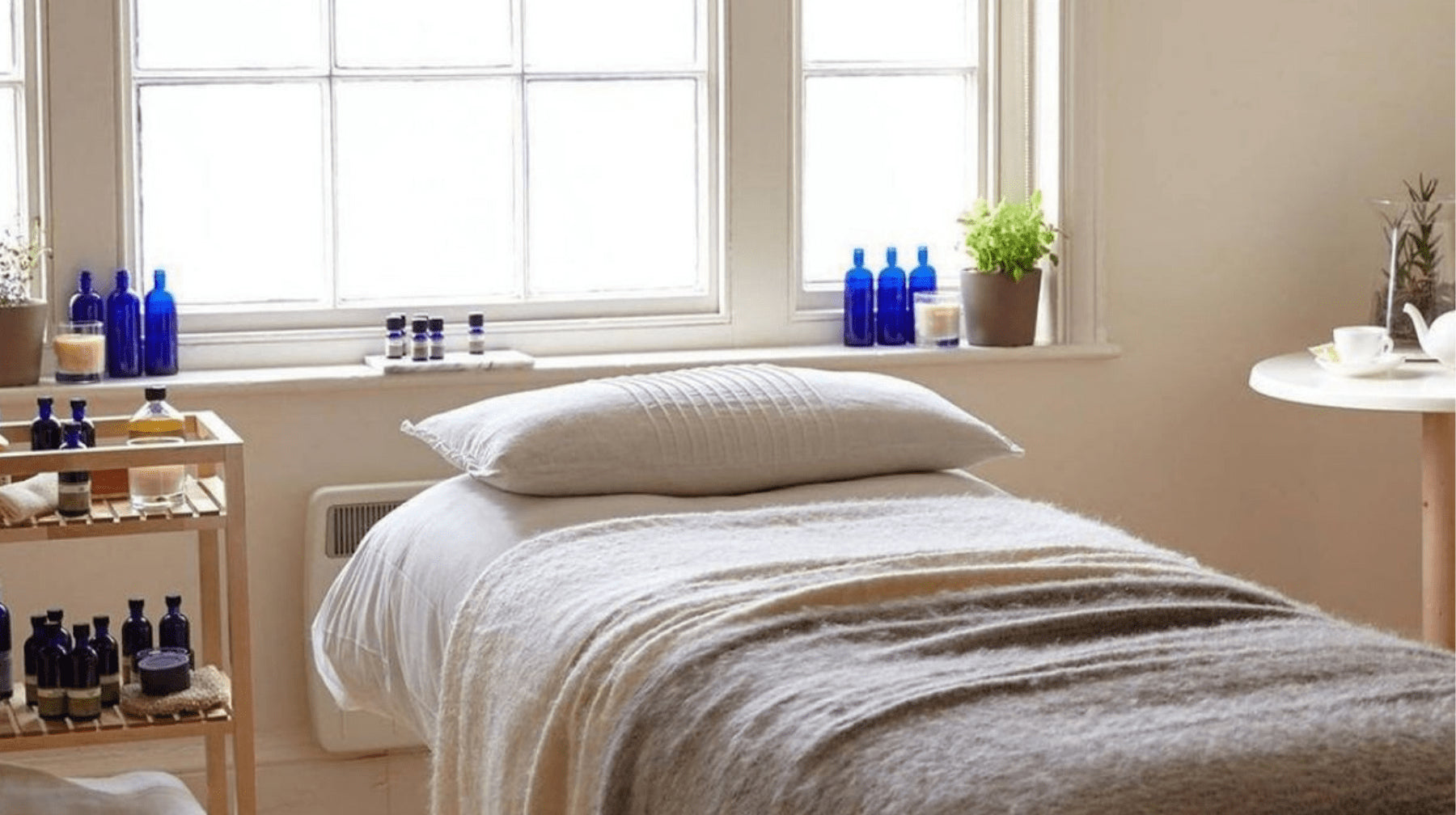 A massage bed with Neal's Yard Remedies products around the therapy room