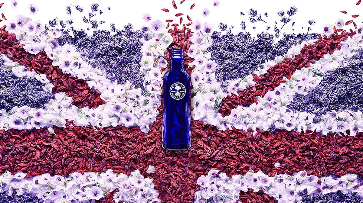 A Neal's Yard Remedies blue bottle on a Union Jack flag made of flowers