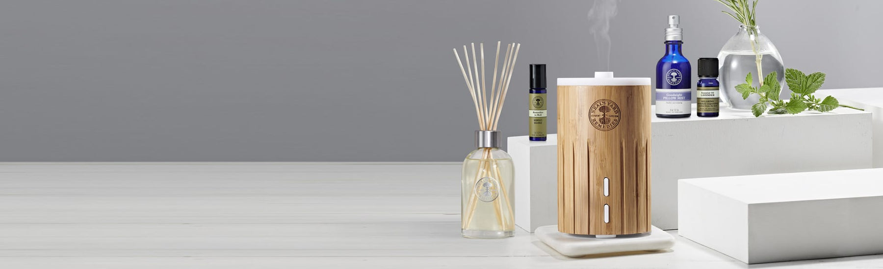 Picture of home fragrance products, including electric diffuser, reed diffuser, aromatherapy oils and pillow mist by Neal's Yard Remedies