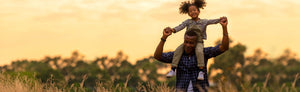 Picture of a father carrying her daughter on his shoulder 