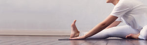 Picture of a woman doing stretches in white clothing 