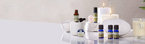 Picture of aromatherapy oils and flower essence blend surrounded with candles by Neal's Yard Remedies