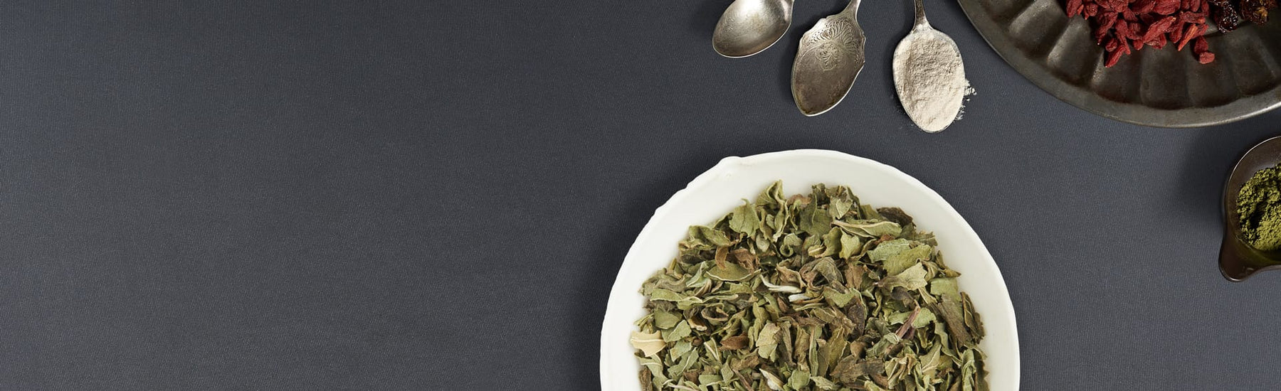 Picture of dried herb in white bowl dark background by Neal's Yard Remedies