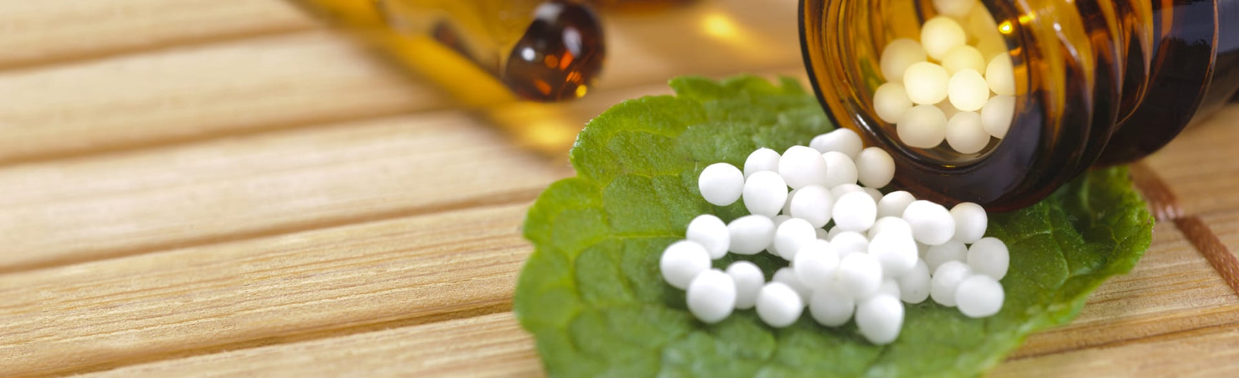 Picture of homoeopathic pills rolling on a leaf