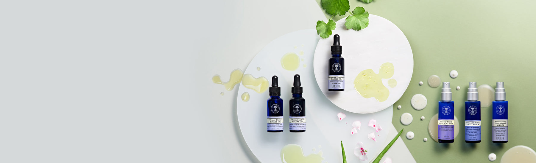 Picture displaying different facial oils and serums on green and white background by Neal's Yard Remedies