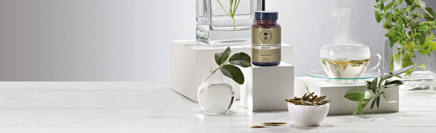 Picture of a supplement surrounded with glass decor and herbs by Neal's Yard Remedies